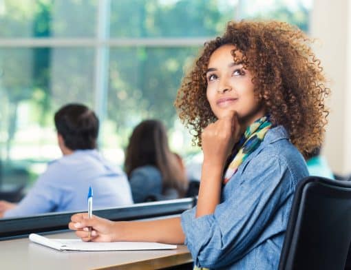 Mulher jovem negra, estudante, pensando com a mão no queixo